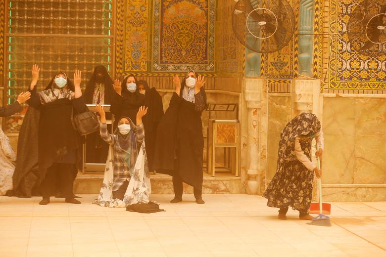 دعا کردن زائران ایرانی همزمان با وقوع طوفان شن، بارگاه مطهر حضرت علی(ع)، نجف اشرف، عراق